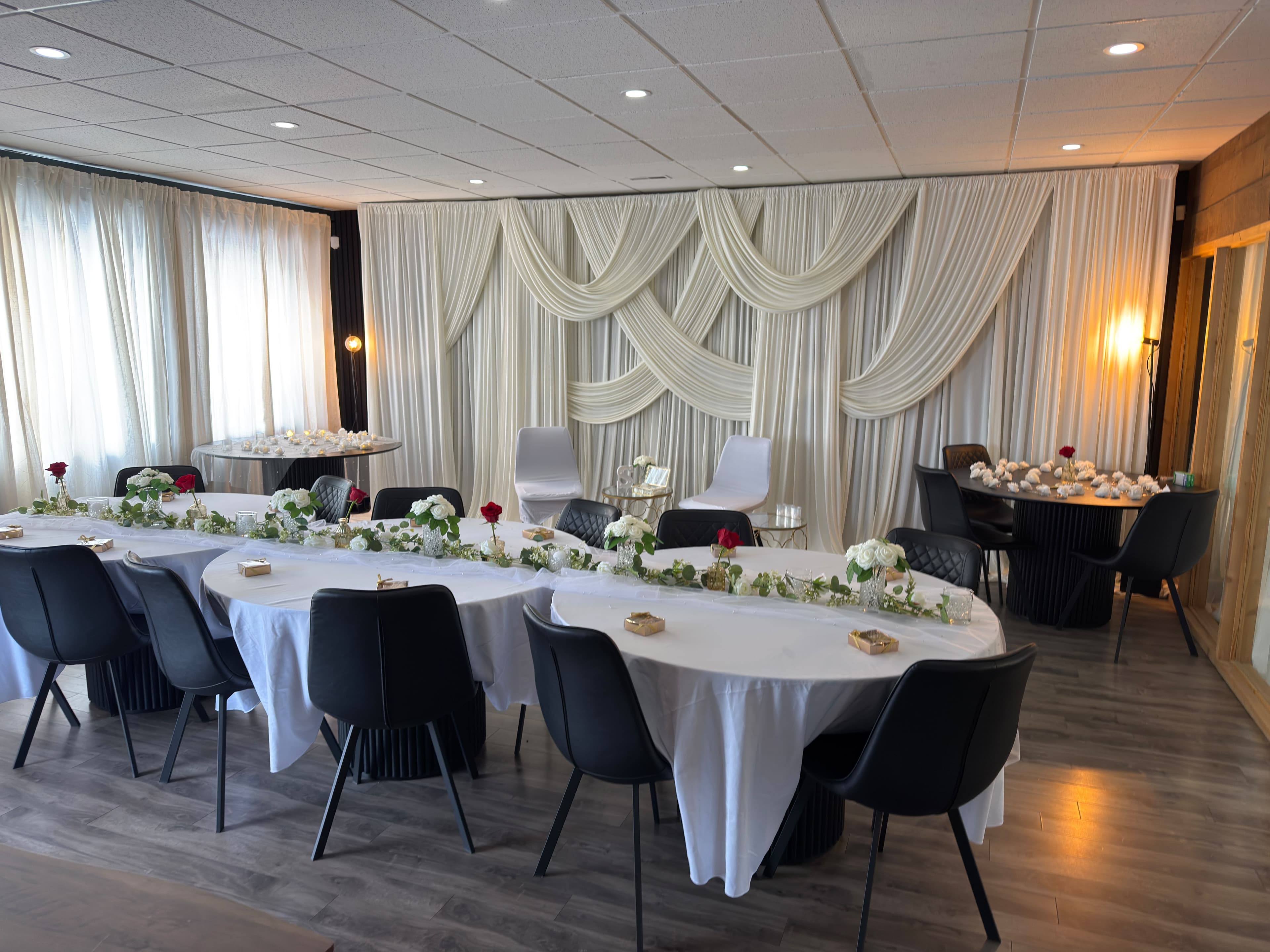 KLAS Studio set for an intimate wedding reception with a draped backdrop and floral tables